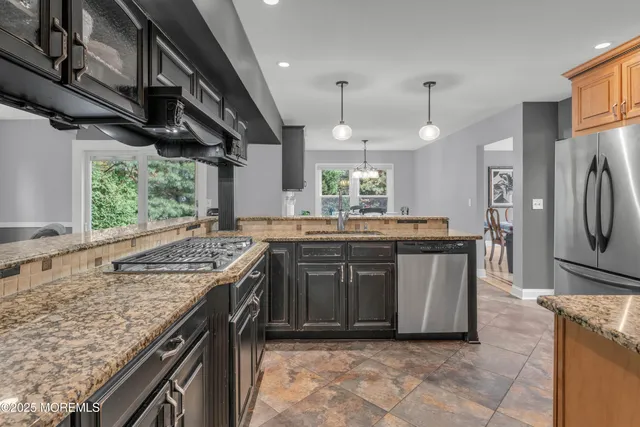 a kitchen with stainless steel appliances granite countertop a stove a sink and a refrigerator