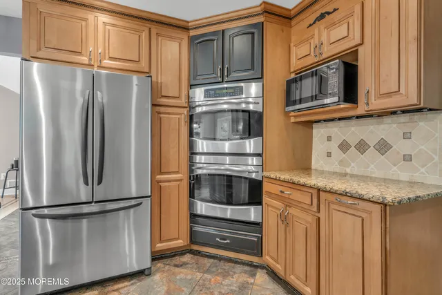 a kitchen with stainless steel appliances granite countertop a refrigerator and microwave