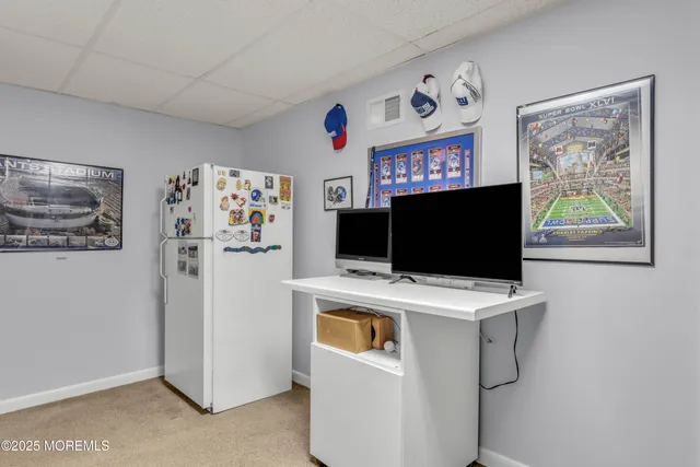a view of a living room with a flat screen tv and a refrigerator