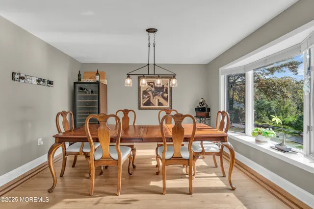 a dining room with furniture a chandelier and wooden floor