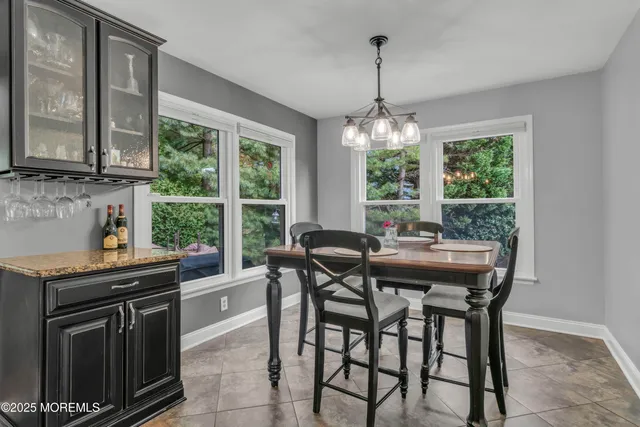 a dining room with furniture a chandelier and window