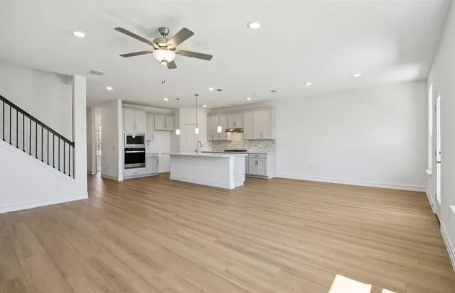 a view of kitchen with granite countertop cabinets and refrigerator