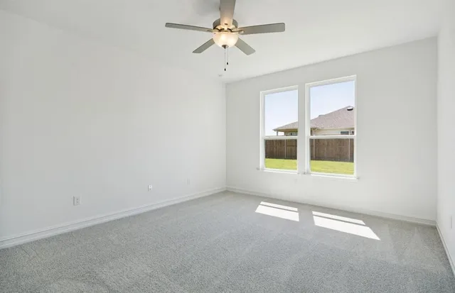 an empty room with a window and a ceiling fan