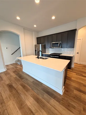 a large kitchen with stainless steel appliances a large counter top