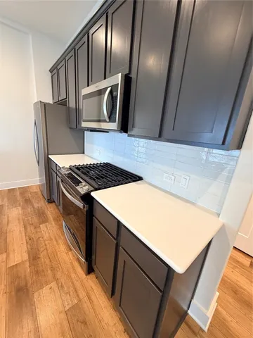 a kitchen with stainless steel appliances granite countertop a stove a sink and a refrigerator