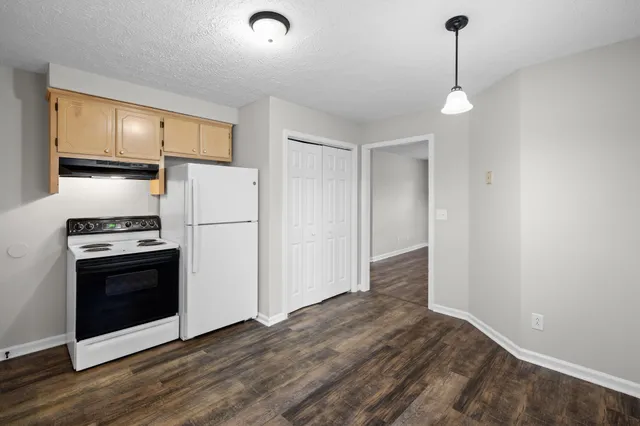 a kitchen with a refrigerator and a stove top oven