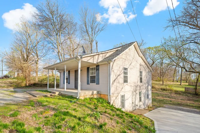 a view of a house with a yard and pathway