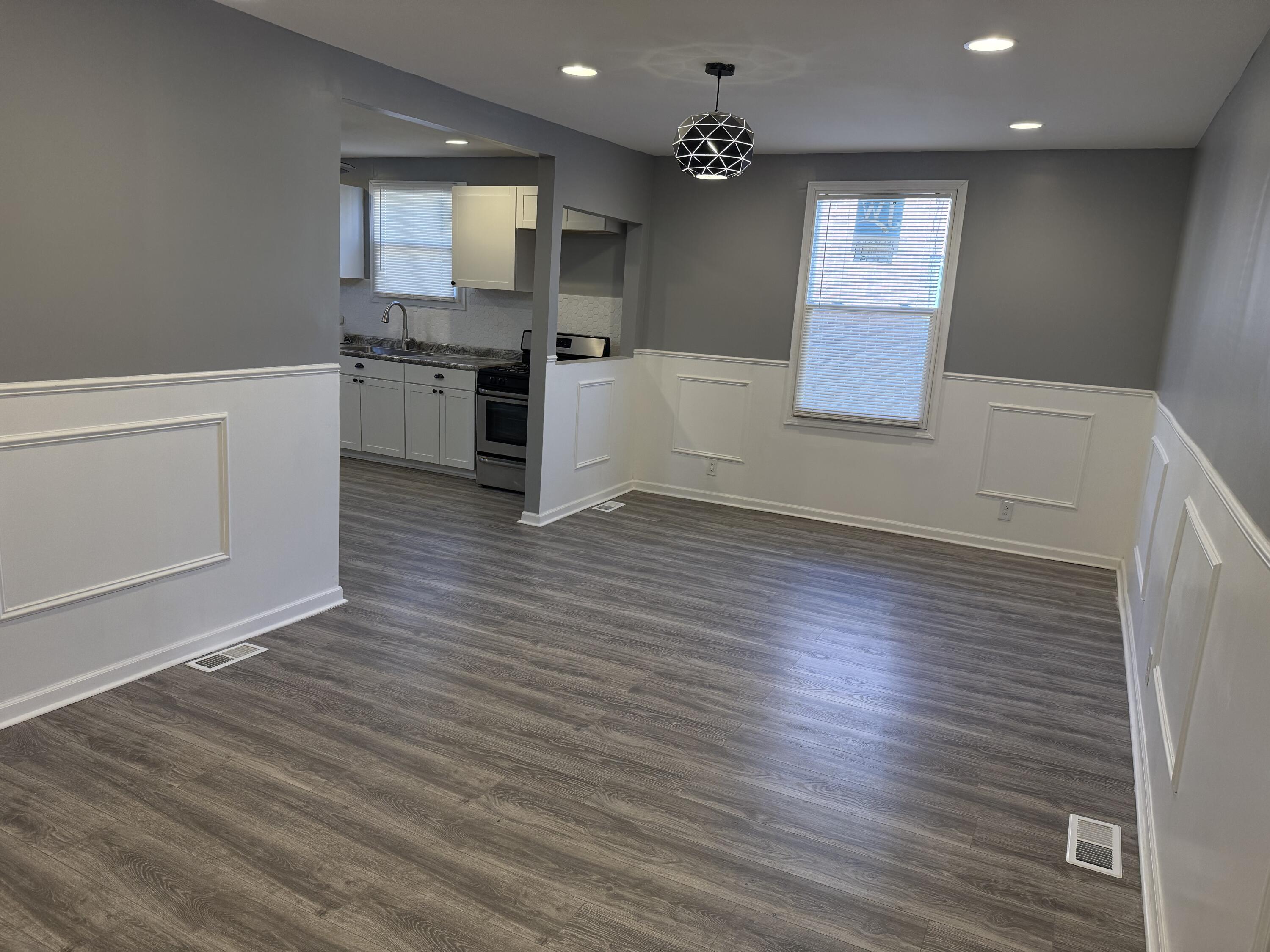 634 Kentucky Street Gary, IN 46402 - Photo 8 of 18 an empty room with wooden floor and kitchen view