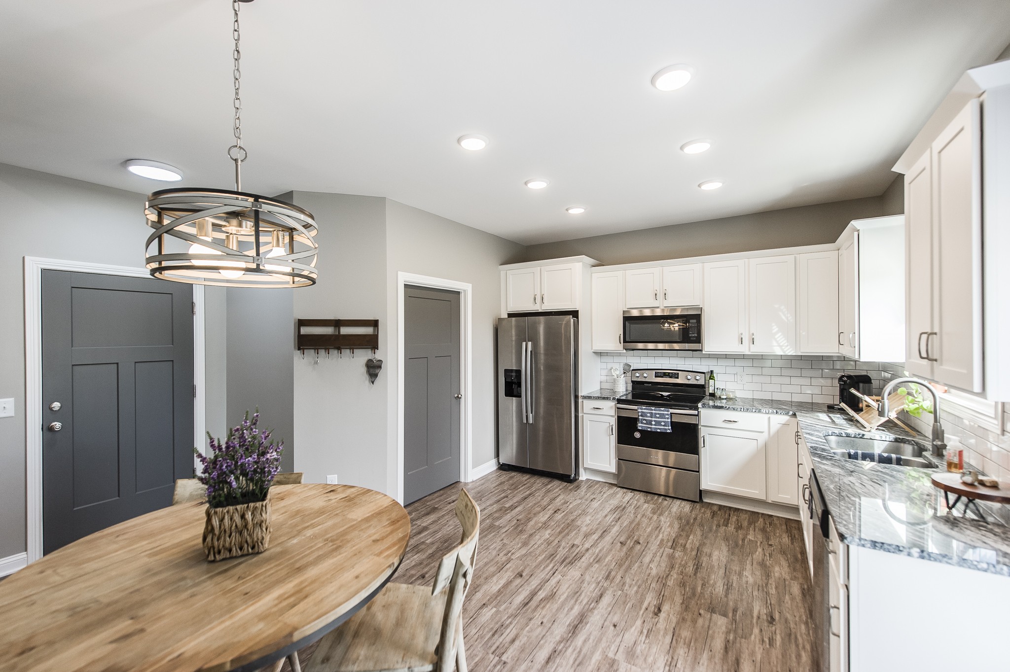 1502 Rock Bridge Road Bethpage, TN 37022 - Photo 14 of 37 a kitchen with stainless steel appliances kitchen island granite countertop a refrigerator oven a sink dishwasher and a dining table with wooden floor