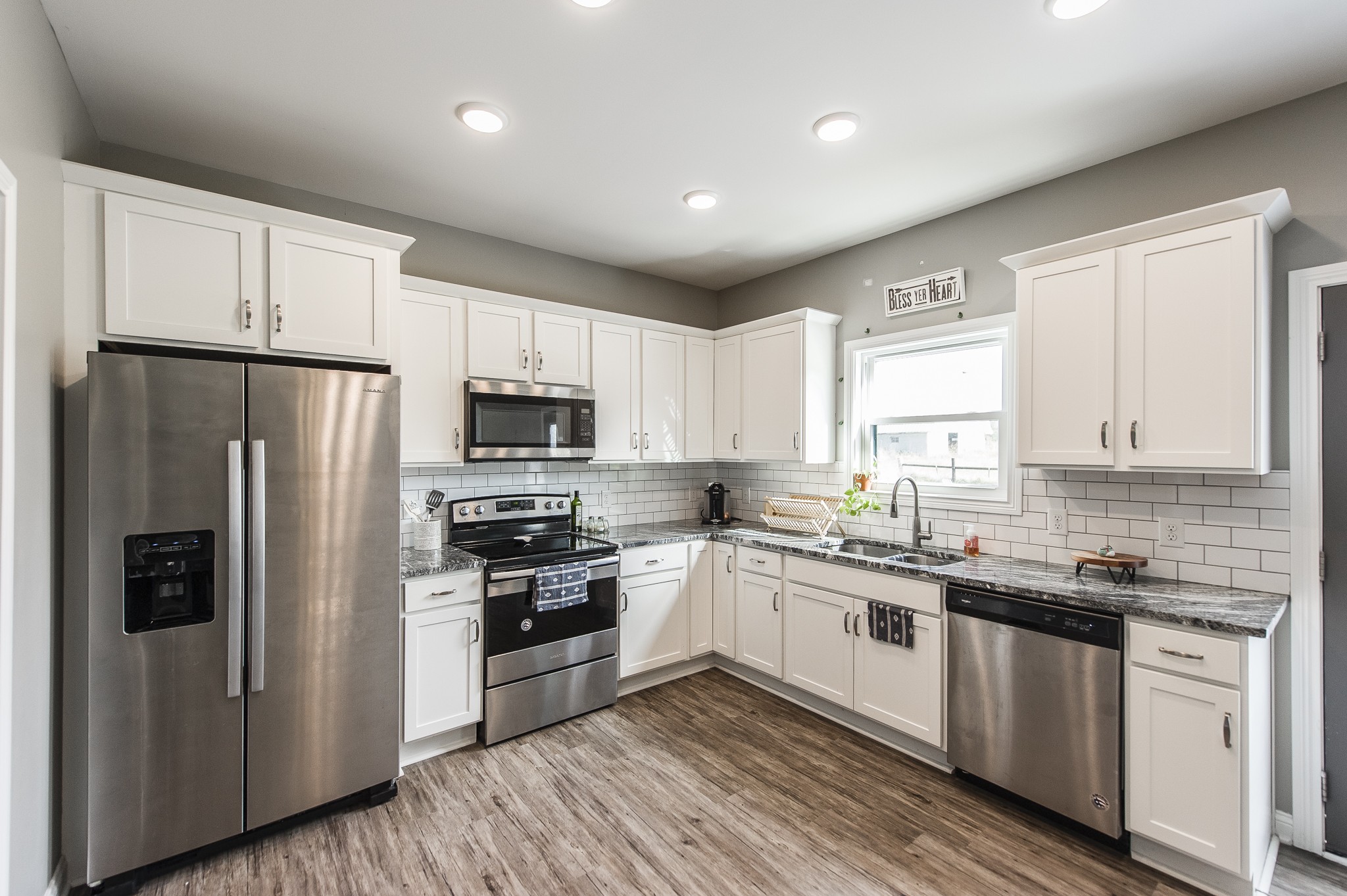 1502 Rock Bridge Road Bethpage, TN 37022 - Photo 15 of 37 a kitchen with stainless steel appliances granite countertop a refrigerator a sink dishwasher a stove top oven a refrigerator with white cabinets and wooden floor