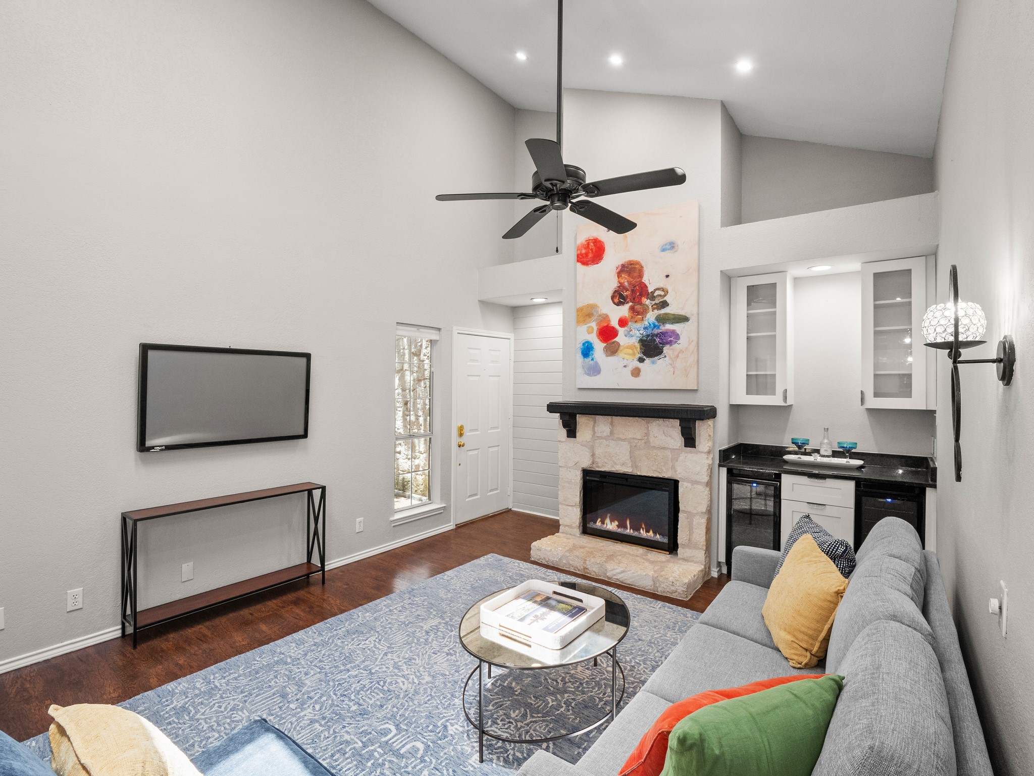 3809 Spicewood Springs Road, Unit 137 Austin, TX 78759 - Photo 3 of 34 Lofty ceilings crown a welcoming living space, anchored by a stone fireplace and sophisticated bar w/ wine and beverage fridges.