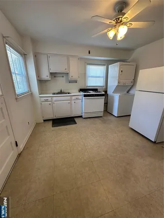 a kitchen with stainless steel appliances a sink a stove top oven a counter space and cabinets
