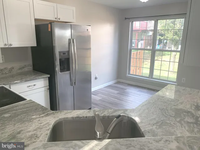 a view of a kitchen cabinets a sink dishwasher a refrigerator and wooden cabinets