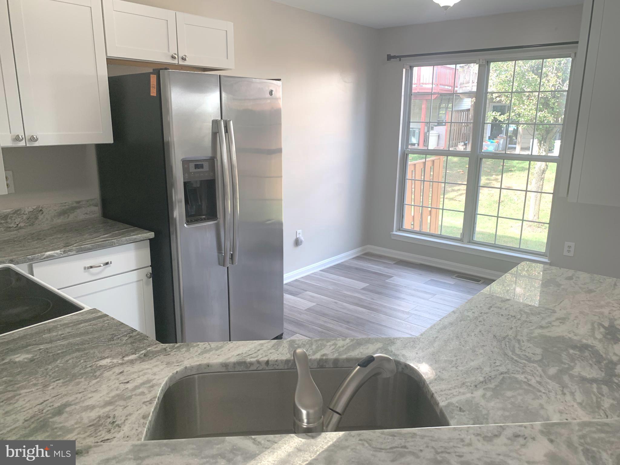 224 Gentlebrook Road Owings Mills, MD 21117 - Photo 7 of 24 a view of a kitchen cabinets a sink dishwasher a refrigerator and wooden cabinets