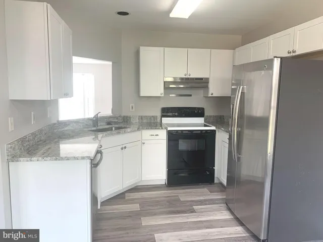 a kitchen with a sink stove and refrigerator