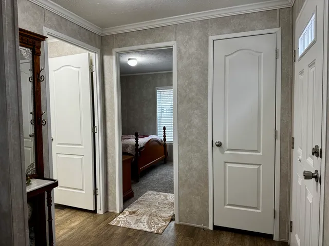 a view of a hallway with wooden floor and closet