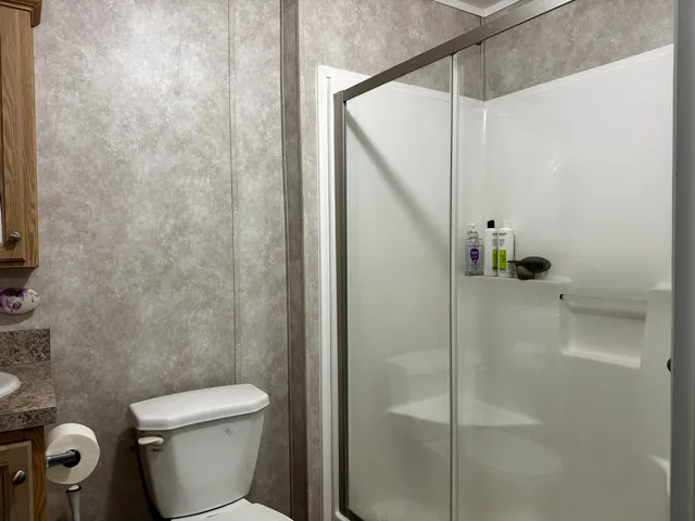 a bathroom with a toilet and a shower