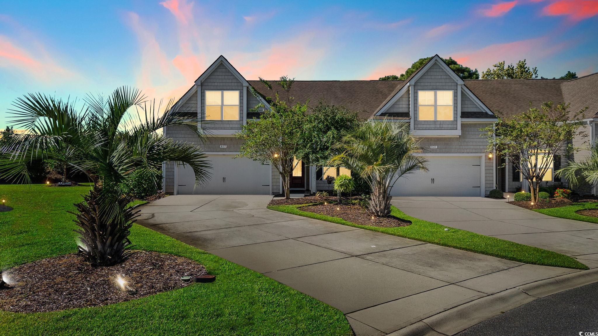 View of front facade featuring driveway, an attached garage, and a front lawn