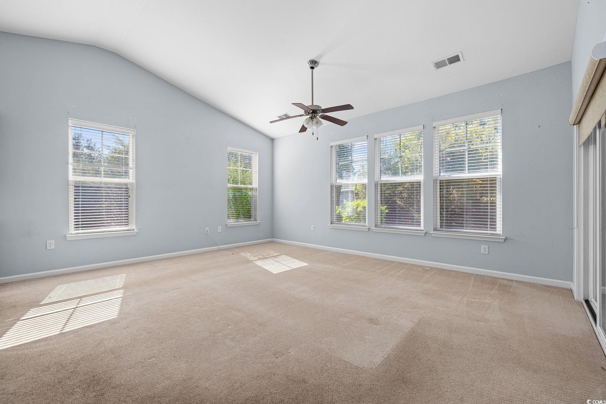 817 Arezzo Way, Unit 1001 Myrtle Beach, SC 29579 - Photo 12 of 40 Spare room featuring lofted ceiling, healthy amount of natural light, light colored carpet, and a ceiling fan