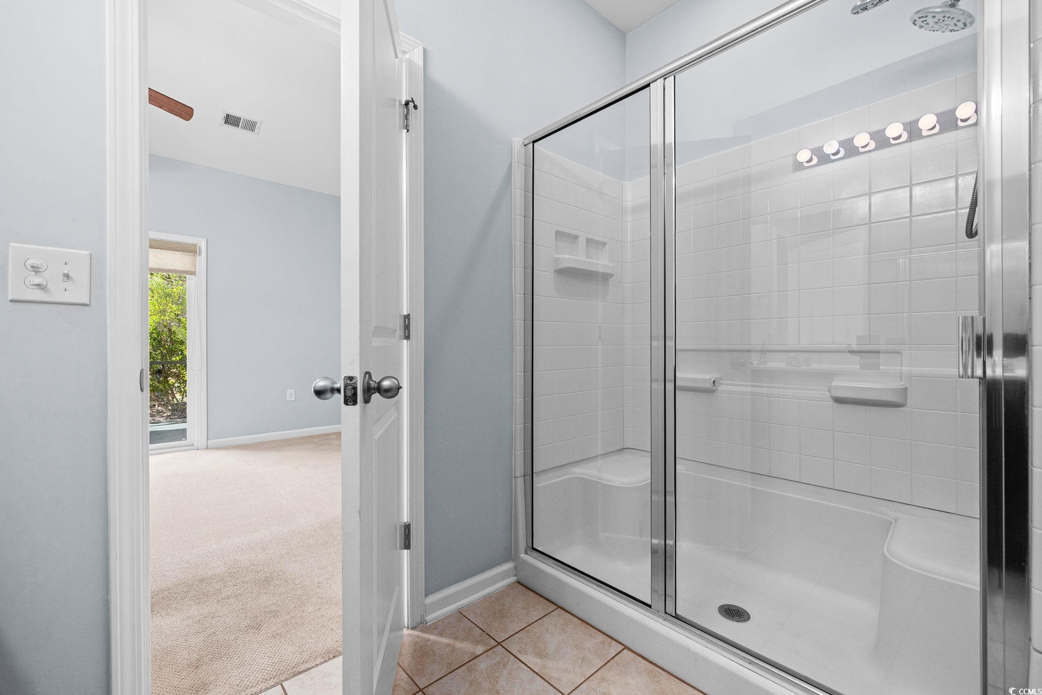 817 Arezzo Way, Unit 1001 Myrtle Beach, SC 29579 - Photo 26 of 40 Full bathroom with light tile patterned flooring, a shower stall, and light carpet
