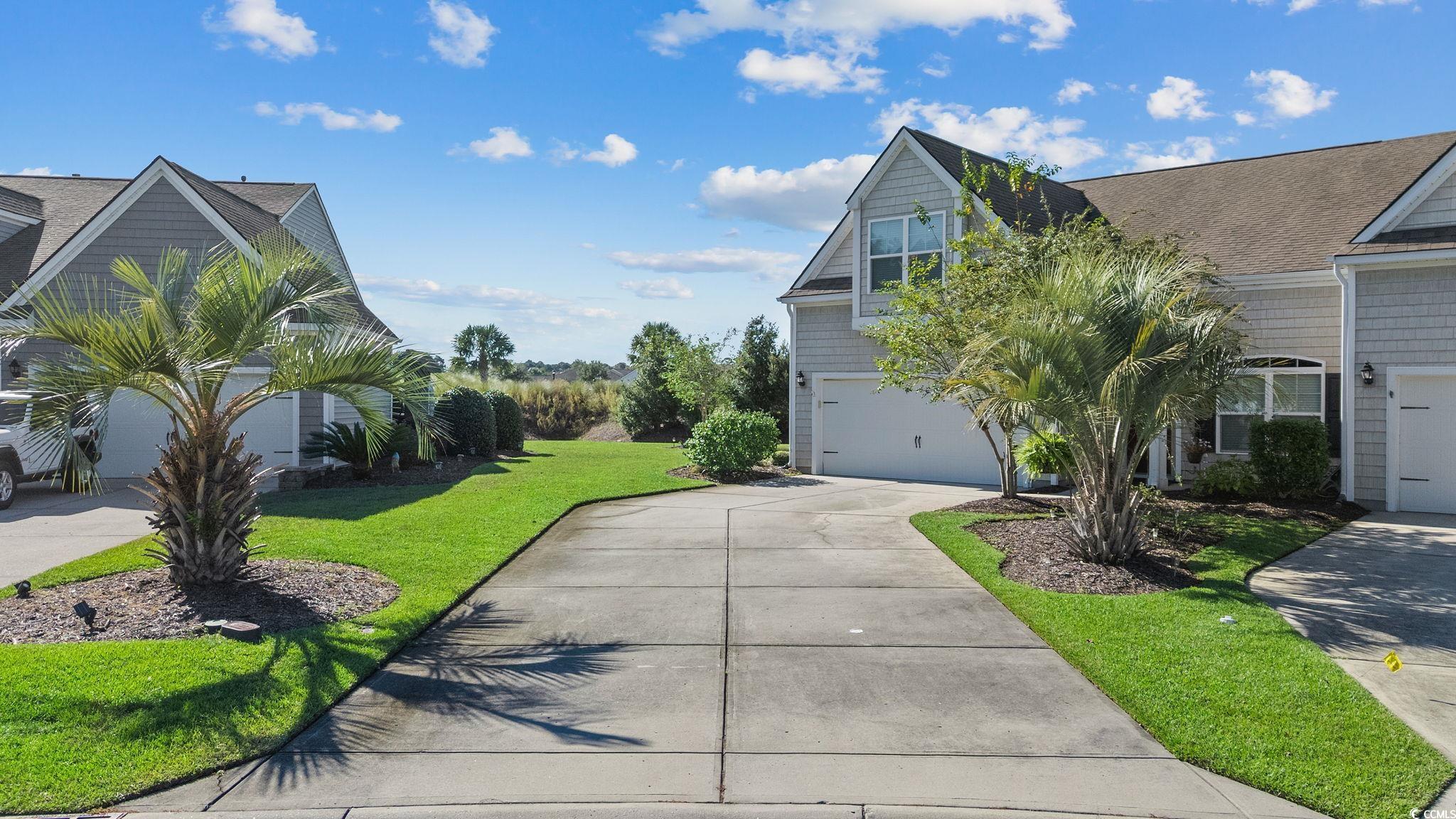 817 Arezzo Way, Unit 1001 Myrtle Beach, SC 29579 - Photo 3 of 40 View of property exterior with a yard, driveway, and an attached garage