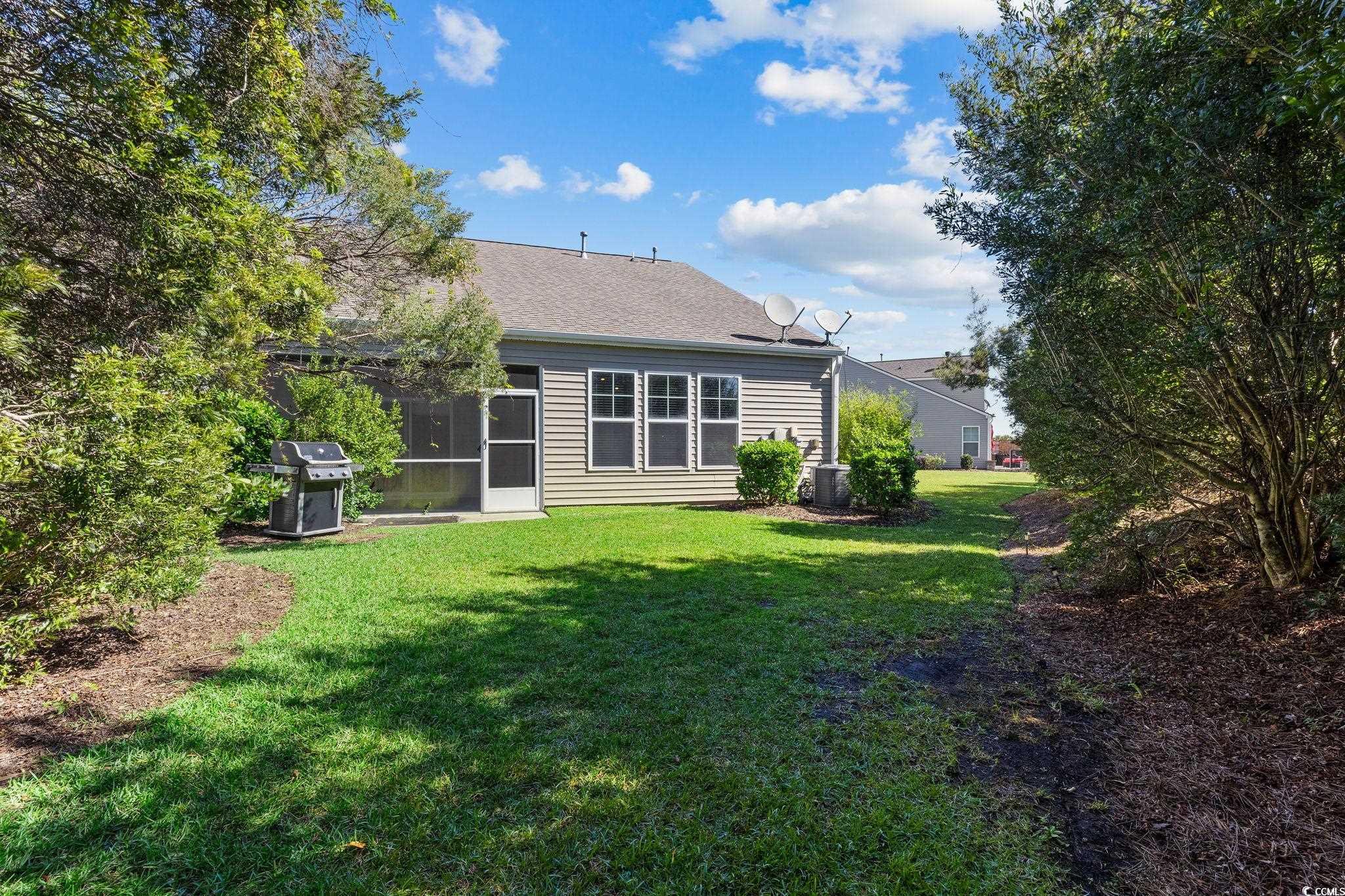817 Arezzo Way, Unit 1001 Myrtle Beach, SC 29579 - Photo 36 of 40 Back of property featuring a lawn, a sunroom, and roof with shingles