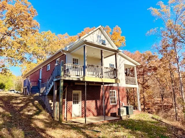 a view of a house with large trees and stairs