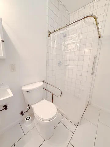 a white toilet sitting next to a shower