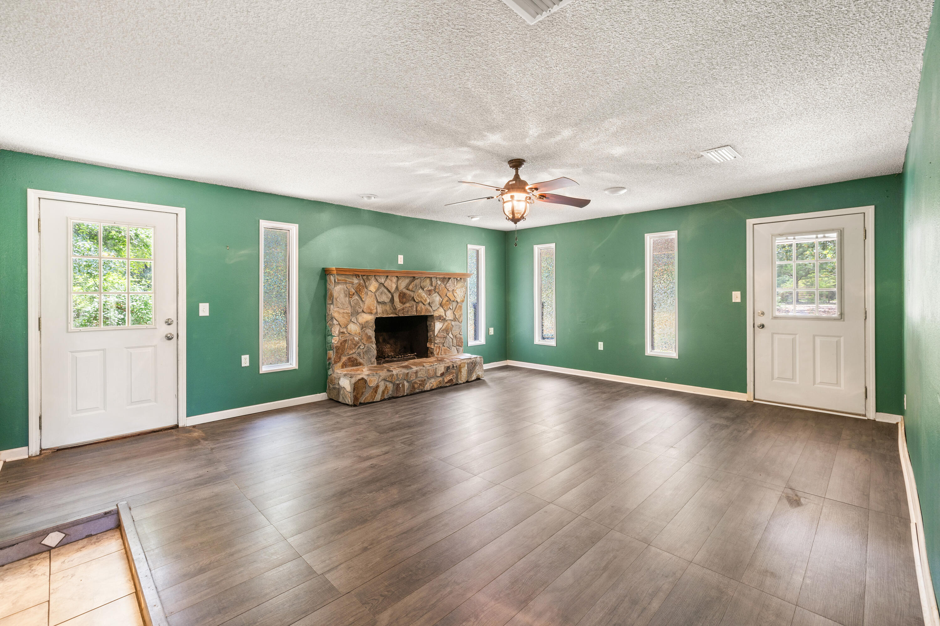 540 John King Road Crestview, FL 32539 - Photo 23 of 59 an empty room with fireplace and wooden floor