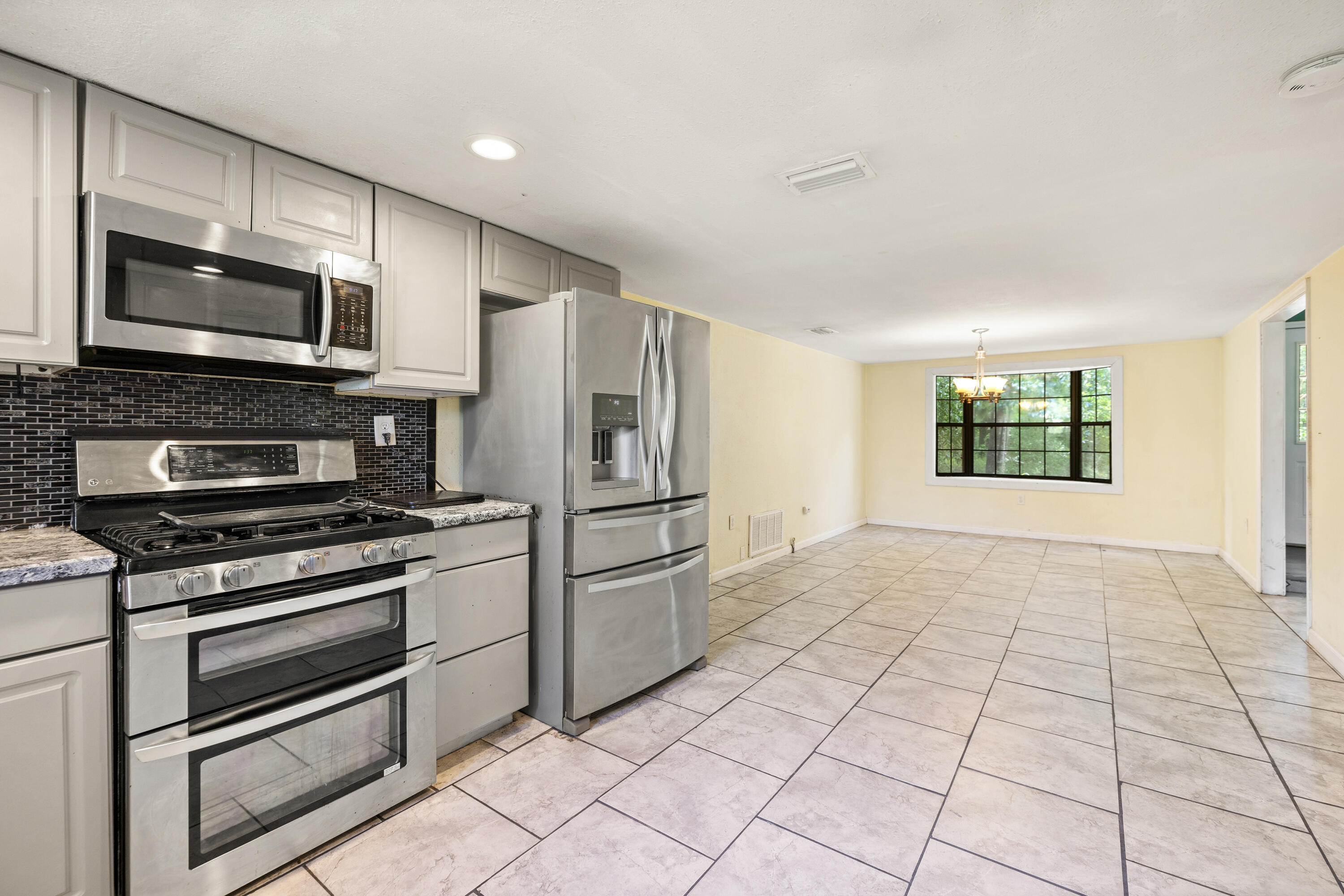 540 John King Road Crestview, FL 32539 - Photo 30 of 59 a kitchen with stainless steel appliances a stove a microwave and a refrigerator
