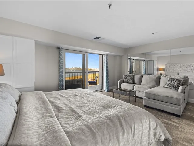 a spacious bedroom with a bed and a lamp