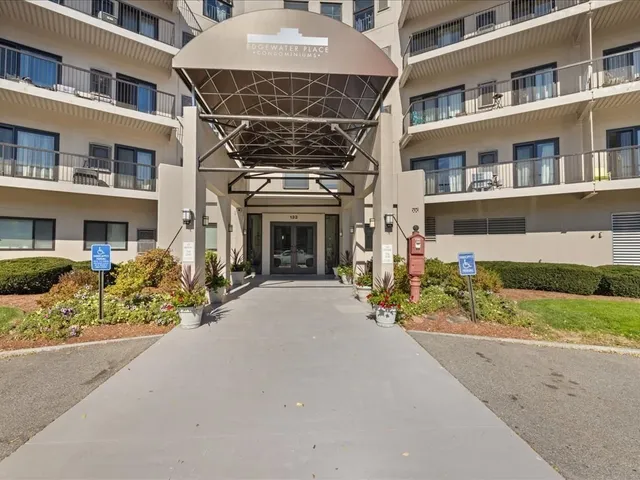a view of a city street with cars and a large building