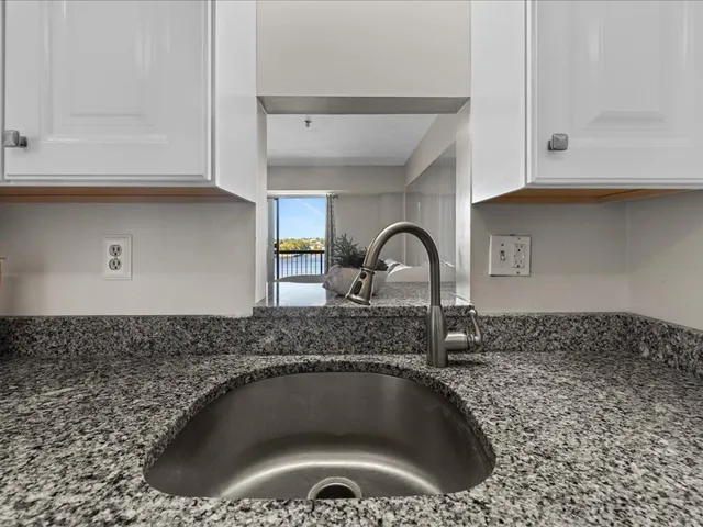 a kitchen with stainless steel appliances white cabinets and a stove top oven