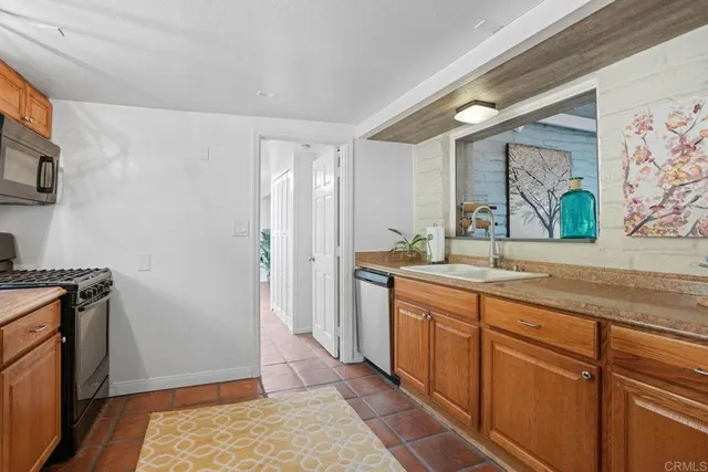 a kitchen with stainless steel appliances a refrigerator sink and microwave