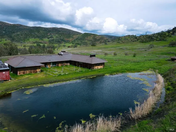 an aerial view of a house with yard and green space