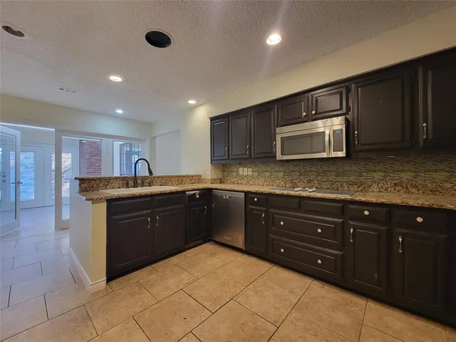 a kitchen with stainless steel appliances granite countertop a sink and cabinets