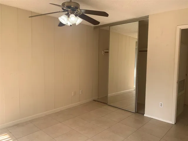 a view of a room with wooden floor and a ceiling fan