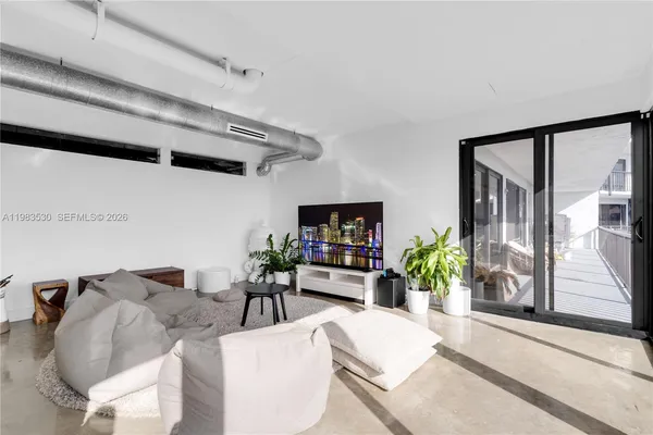 a living room with furniture potted plant and a large window
