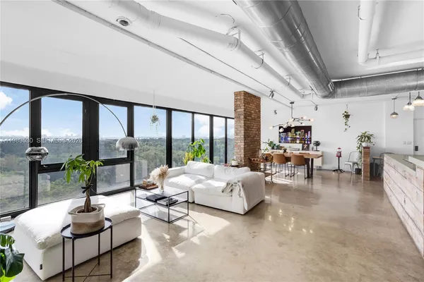 a living room with furniture and large windows