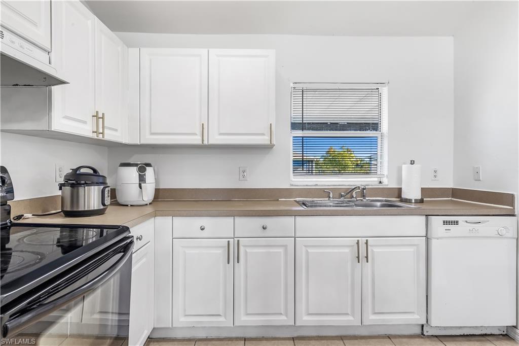 681-683 Alabama Road South, Unit 683 Lehigh Acres, FL 33974 - Photo 23 of 35 a kitchen with granite countertop white cabinets and appliances