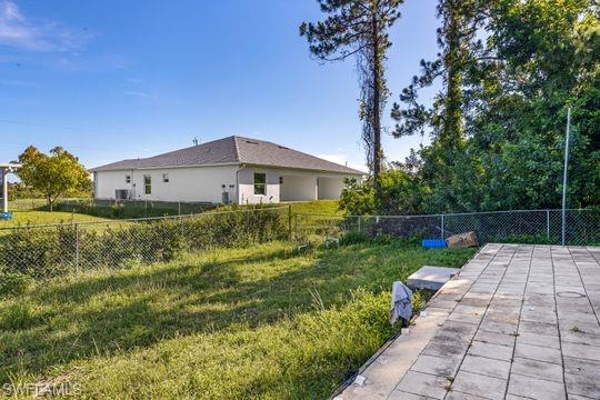 681-683 Alabama Road South, Unit 683 Lehigh Acres, FL 33974 - Photo 31 of 35 a backyard of a house with plants and large trees