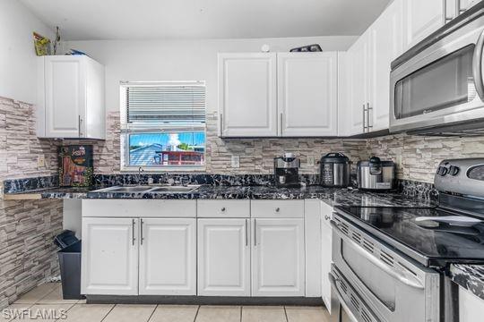 681-683 Alabama Road South, Unit 683 Lehigh Acres, FL 33974 - Photo 9 of 35 a kitchen with stainless steel appliances granite countertop a sink stove and cabinets