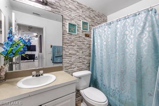 681-683 Alabama Road South, Unit 683 Lehigh Acres, FL 33974 - Photo 10 of 35 a bathroom with a sink a toilet a mirror and shower curtain