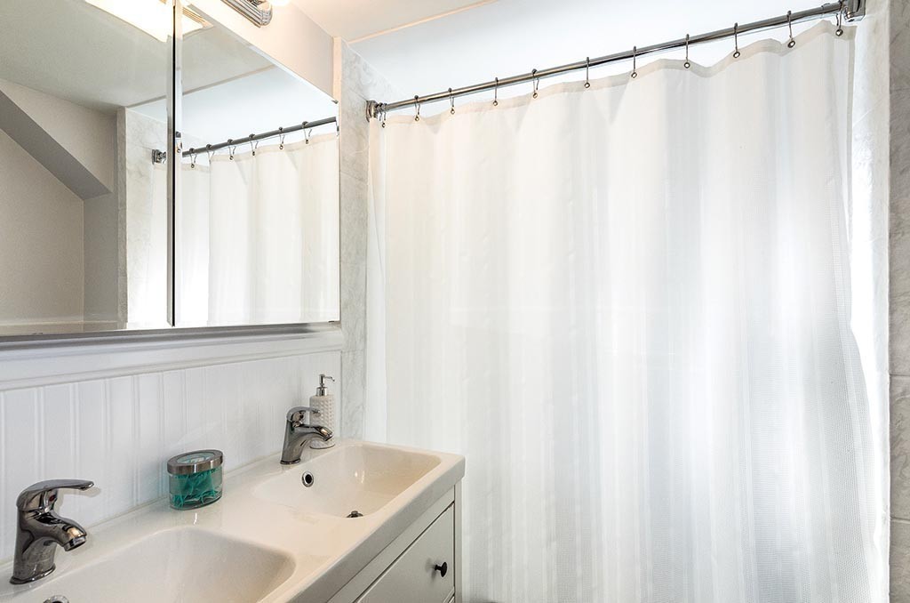 68 Bow Road Newton, MA 02459 - Photo 11 of 16 a bathroom with a sink a mirror and a shower curtain