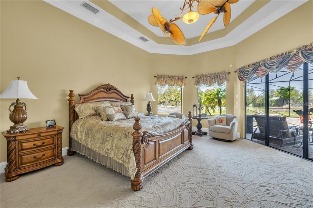 28959 Smugglers Lane Punta Gorda, FL 33982 - Photo 17 of 45 a spacious bedroom with a bed and large windows