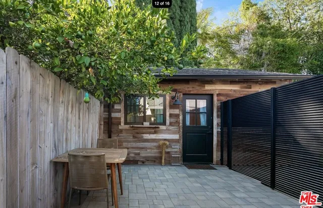 a backyard of a house with barbeque oven and outdoor seating