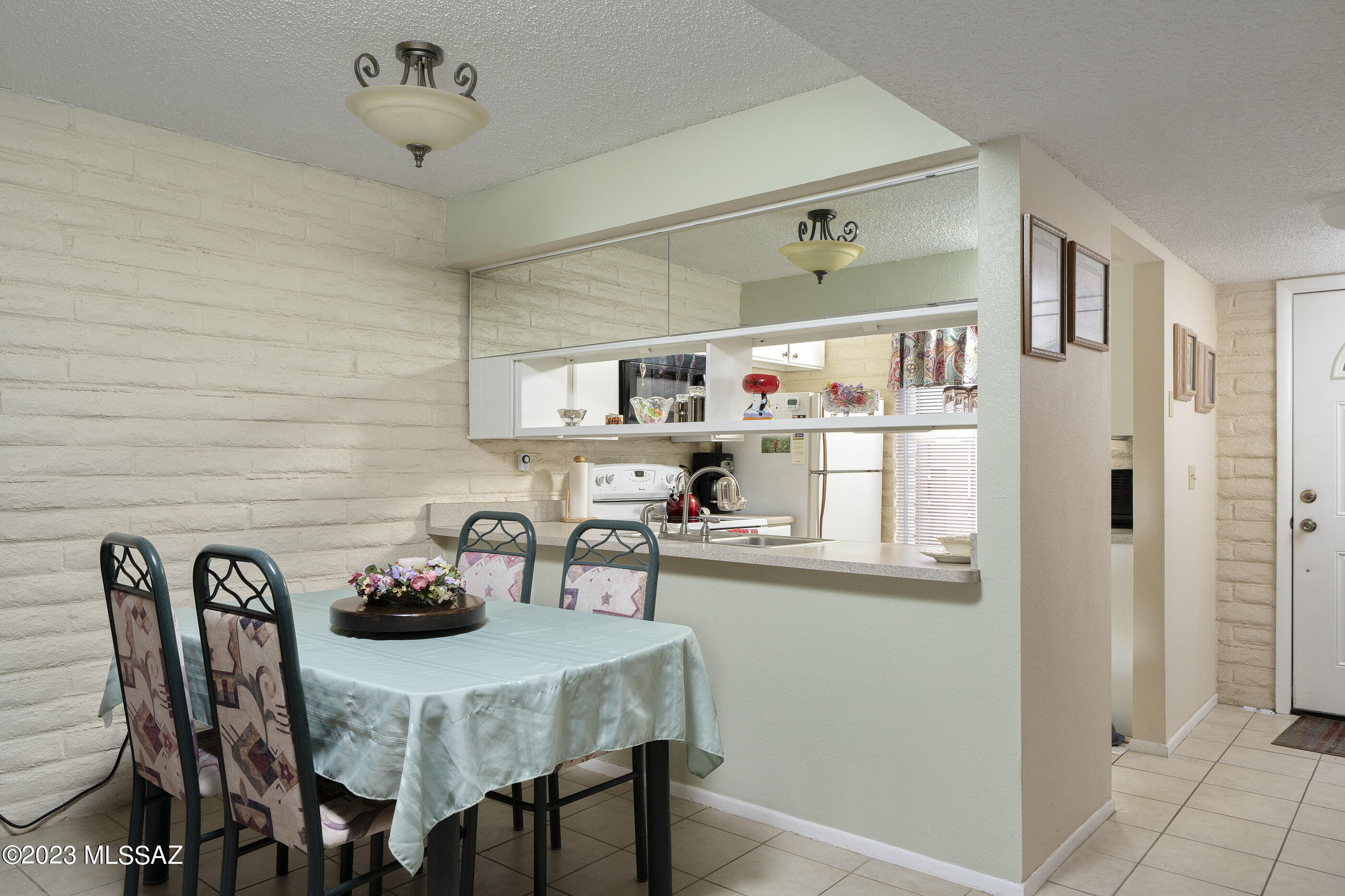 670 South Pantano Road, Unit E Tucson, AZ 85710 - Photo 4 of 17 a kitchen with stainless steel appliances a table chairs and a refrigerator
