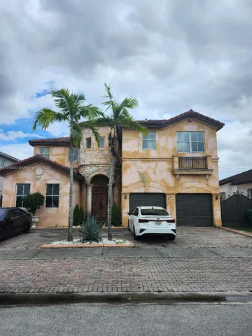 a front view of a house with a garden and parking