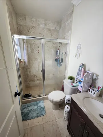 a bathroom with a sink a toilet a mirror and shower