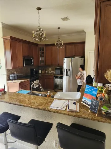 a view of a dining room and livingroom with furniture wooden floor a rug and a chandelier